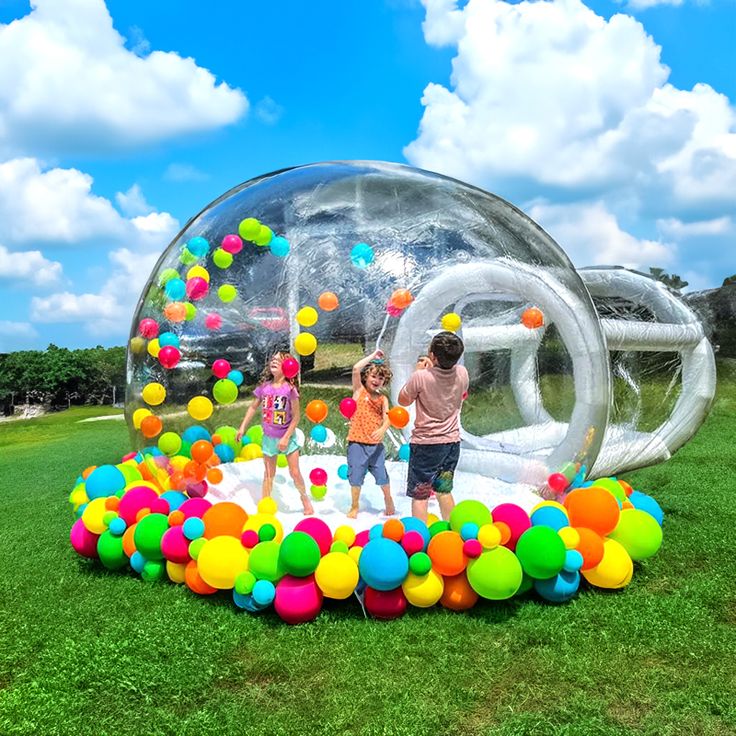 Kids playing joyfully in a pastel-colored bubble house at a party